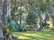 Tranquil yard featuring mature trees, verdant lawns, and diverse plant life for a serene setting at 10975 Sw 69Th Cir, Ocala, FL 34476