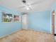 Bright bedroom with light blue walls, ceiling fan, and ample closet space at 11754 Se 123Rd St, Belleview, FL 34420