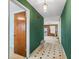 Green hallway with wood door and view into living room at 11754 Se 123Rd St, Belleview, FL 34420