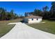 Charming single-story home featuring a large driveway and well-maintained lawn on a sunny day at 12205 Sw 71St Lane Rd, Ocala, FL 34481