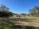 Expansive lot showcasing home nestled among mature trees under a clear blue sky at 12205 Sw 71St Lane Rd, Ocala, FL 34481
