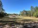 Expansive lot showcasing home nestled among mature trees under a clear blue sky at 12205 Sw 71St Lane Rd, Ocala, FL 34481