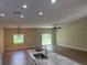 Bright, open floor plan with a kitchen island featuring stone countertops and undermount sink and stainless faucet, with views to backyard at 12205 Sw 71St Lane Rd, Ocala, FL 34481