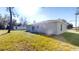 Rear view of a light gray house with sliding glass doors and a small patio at 232 Locust Pass, Ocala, FL 34472