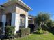 Tan house with white columns, landscaping, and a black fence at 3642 Nw 55Th Cir, Ocala, FL 34482