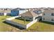 Aerial view of fenced backyard with a lawn and solar panels on the roof at 547 Tanaro Ln, Haines City, FL 33844