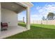 A backyard featuring a covered patio area with seating, a well-maintained lawn, and a privacy fence at 547 Tanaro Ln, Haines City, FL 33844