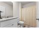 A well-lit bathroom featuring a granite vanity, toilet, and a shower with a gold curtain at 547 Tanaro Ln, Haines City, FL 33844