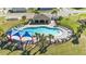 Aerial shot of a pool with shade umbrellas, chairs, and surrounding landscaping at 547 Tanaro Ln, Haines City, FL 33844