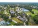 Aerial view of community center with large parking area, golf course, and mature landscaping at 10886 Sw 90Th Ter, Ocala, FL 34481