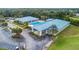 Aerial view of the clubhouse, pool, and parking area, all surrounded by lush landscaping at 10886 Sw 90Th Ter, Ocala, FL 34481