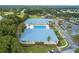 Aerial view of community pool and clubhouse with stunning landscaping and parking area at 10886 Sw 90Th Ter, Ocala, FL 34481