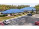 Exterior view of community buildings with blue roofs and a well-maintained parking area with accessible spaces at 10886 Sw 90Th Ter, Ocala, FL 34481