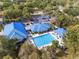 High angle view of resort-style pool, lounge chairs, tables, and lush tropical landscaping at 10886 Sw 90Th Ter, Ocala, FL 34481