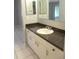 This bathroom features a dark countertop, white cabinetry, and tile flooring for a clean, modern look at 11354 Sw 138Th Pl, Dunnellon, FL 34432