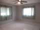 Bright empty bedroom with tile flooring and two windows for natural light at 11354 Sw 138Th Pl, Dunnellon, FL 34432