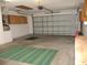 Spacious two-car garage with overhead storage and utility cabinets at 11354 Sw 138Th Pl, Dunnellon, FL 34432