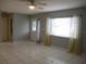 Spacious living room features tile flooring and natural light from large window at 11354 Sw 138Th Pl, Dunnellon, FL 34432