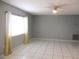 Bright living room with ceiling fan and white tile flooring at 11354 Sw 138Th Pl, Dunnellon, FL 34432