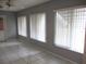 Living room featuring tile flooring, a ceiling fan, and three windows with blinds at 11354 Sw 138Th Pl, Dunnellon, FL 34432