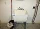 Close up of utility sink in the garage with a mop and plumbing at 11354 Sw 138Th Pl, Dunnellon, FL 34432