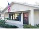 Front view of a charming house with a red door and American flag at 12467 Se 62Nd Ave, Belleview, FL 34420