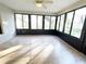 Sunroom with vinyl flooring and ceiling fan; backyard view at 12467 Se 62Nd Ave, Belleview, FL 34420