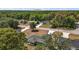 Aerial view of homes in a verdant neighborhood, set against a bright sky with a distant butte at 176 Pine Crse, Ocala, FL 34472