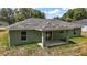 A backyard view showing a covered patio with sliding glass doors and an expansive lawn at 176 Pine Crse, Ocala, FL 34472