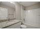 Bright bathroom features a granite countertop, a tub with shower, and a large mirror at 176 Pine Crse, Ocala, FL 34472