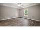 Light-filled bedroom with wood-look floors, a ceiling fan, and a large window for natural light at 176 Pine Crse, Ocala, FL 34472