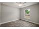 Cozy bedroom features wood-look floors, a ceiling fan, and a window for natural light at 176 Pine Crse, Ocala, FL 34472