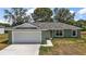 Charming home featuring a two-car garage, and a well-manicured lawn at 176 Pine Crse, Ocala, FL 34472