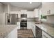 This kitchen has white cabinetry, granite countertops, an island, and stainless-steel appliances at 176 Pine Crse, Ocala, FL 34472