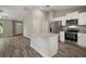 Open-concept kitchen features granite countertops, stainless steel appliances, an island, and wood-look flooring at 176 Pine Crse, Ocala, FL 34472