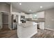 Bright kitchen features stainless steel appliances, granite countertops, white cabinets, and an island at 176 Pine Crse, Ocala, FL 34472
