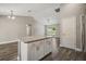 Open living area features wood-look flooring, neutral paint, an island, and lots of natural light at 176 Pine Crse, Ocala, FL 34472
