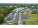 An aerial photograph of a blue-roofed community center, surrounded by a parking area and verdant green spaces at 6688 Sw 113Th Pl, Ocala, FL 34476