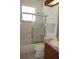 This bathroom features a tiled shower over tub, toilet, and vanity with wood cabinets at 6688 Sw 113Th Pl, Ocala, FL 34476