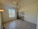 Minimalist bedroom with a ceiling fan, large window with blinds, and metal shelving unit at 6688 Sw 113Th Pl, Ocala, FL 34476