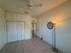 Cozy bedroom featuring built-in closets, a ceiling fan, and warm lighting from a floor lamp at 6688 Sw 113Th Pl, Ocala, FL 34476