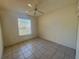 Bright bedroom features tile flooring, a ceiling fan, and a window that allows natural light to fill the space at 6688 Sw 113Th Pl, Ocala, FL 34476