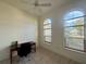 This bedroom features a ceiling fan, tile floors, and two arched windows at 6688 Sw 113Th Pl, Ocala, FL 34476