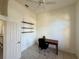 This bedroom features a ceiling fan, a door, tile floors, and a shelving unit at 6688 Sw 113Th Pl, Ocala, FL 34476