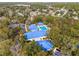 Aerial view of a community center with a pool surrounded by lots of green trees at 6688 Sw 113Th Pl, Ocala, FL 34476