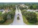 Aerial view of a neighborhood entrance with guard house, gate and long residential street at 6688 Sw 113Th Pl, Ocala, FL 34476