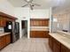 Spacious kitchen with stainless steel refrigerator, wooden cabinetry and breakfast bar at 6688 Sw 113Th Pl, Ocala, FL 34476