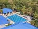 Aerial view of a lap pool with tables, chairs, and mature trees at 6688 Sw 113Th Pl, Ocala, FL 34476