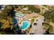 Overhead view of community pools, a spa, patio seating, palm trees, and parking area at 6688 Sw 113Th Pl, Ocala, FL 34476