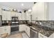 This kitchen features stainless steel appliances, granite countertops, a mosaic backsplash, and ample lighting at 8706 Sw 88Th Pl, Ocala, FL 34481